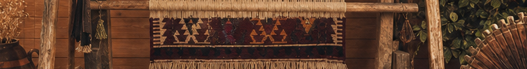 Detail of a kilim in progress on the loom, surrounded by workshop tools